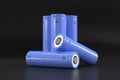 5 blue cylindrical batteries on a black background. Storage battery or secondary cell. Rechargeable li-ion batteries for