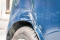 Blue damaged car in crash accident with scratched paint and dented rear bumper metal body, close up selective focus Royalty Free Stock Photo