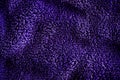 Blue dark delicate soft background of fur plush smooth fabric. Texture of purple soft fleecy blanket textile Royalty Free Stock Photo