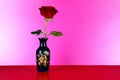 Blue Decorated Flower Vase with Red Rose on a Red Surface and Pink Background Royalty Free Stock Photo