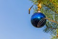 Blue decorative ball on the christmas tree blue sky background. Royalty Free Stock Photo