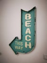 A blue decorative post sign beach this way hanging on the white wall Royalty Free Stock Photo