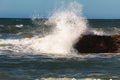 Blue deep sea waves crashing against the rocky shore Royalty Free Stock Photo