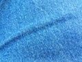 Blue denim jean fabric or textile with a crease
