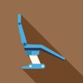 Blue dentist chair casting long shadow on brown background Royalty Free Stock Photo