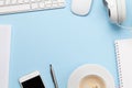 Blue desk with computer, smartphone, supplies and coffee Royalty Free Stock Photo