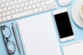 Blue desk with computer, smartphone, supplies and coffee Royalty Free Stock Photo