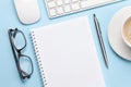 Blue desk with computer, supplies and coffee Royalty Free Stock Photo