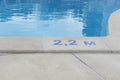 Blue digits and letter as sign of depth in meters in swimming pool, deep pool with blue water, no people around, Royalty Free Stock Photo