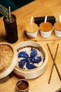 Blue Dim Sum chinese cuisine in bamboo steamer and pot. Top view fresh dumplings with hot steams on wood plate with Royalty Free Stock Photo