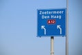 Blue direction sign on motorway A12 heading to Den Haag and Zoetermeer in the Netherlands