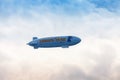 Blue dirigible flying in cloudy sky Royalty Free Stock Photo