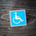 A blue disabled sign, symbol or icon on a wooden block with copy space