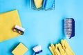 Blue dish brushes, sponges in metal basket, cleaning rag and yellow gloves and sponge on a blue background. Space for