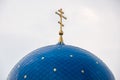 Blue dome of the Christian Church with stars and gold crosses close-up.