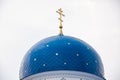 Blue dome of the Christian Church with stars and gold crosses close-up.