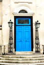 Blue door and the classic facade with metal lamps