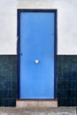Blue door and white and blue tiled facade