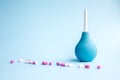 Blue douche and tablets of pink and white in bulk on a blue background