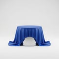 Blue drape covering a round table with a white object inside Royalty Free Stock Photo