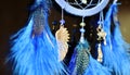 Blue dream catcher hanging on dark background close up with suspension wing