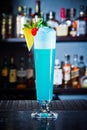 Blue drink cocktail with foam decorated pineapple and cherry in big glass, close up Royalty Free Stock Photo