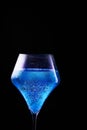 Blue drink is poured into a glass.