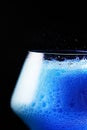 Blue drink is poured into a glass.