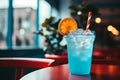a blue drink sitting on a table in front of a window
