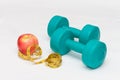 Blue dumbbells, red apple, tape on white background Royalty Free Stock Photo