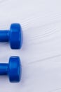 Blue dumbbells on wooden background, cropped image.