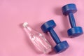 Blue dumbells on the pink yoga matt