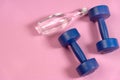 Blue dumbells on the pink yoga matt