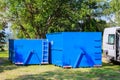 Blue dumpster for municipal waste or industrial waste, on green grass