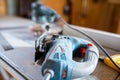 Blue dusty Bosch jigsaw on the table in a small woodworking shop.