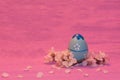 Blue Easter Egg with apricot twig and petals on pink ÃÂ 