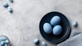 Blue easter eggs in a dark blue plate on a gray concrete background. Royalty Free Stock Photo