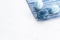 Blue easter eggs on a blue towel. Three eggs in the corner of the frame on a white background. Easter in blue Royalty Free Stock Photo