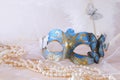blue elegant venetian mask next to pearls