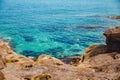 Blue emerald sea water with large stones beach. Rocky shore transparent turquoise bottom Malta Royalty Free Stock Photo