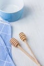 Blue Empty Bowl Wooden Honey Dippers Spoons Cotton Apron on White Table. Holiday Baking Cooking Concept. Christmas Easter