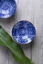 Blue empty bowls for soup or noodles on wooden background with leaf. Oriental layout