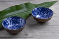 Blue empty bowls on wooden background with leaf. Asian cuisine. Side view