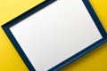 Blue empty picture frame on yellow wall background Royalty Free Stock Photo