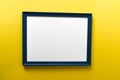 Blue empty picture frame on yellow wall background Royalty Free Stock Photo