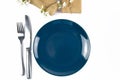 Blue empty plate with fork and knife and gifts decorated with white flowers isolated on white background Royalty Free Stock Photo