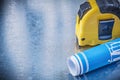 Blue engineering drawings tape measure on metallic background co Royalty Free Stock Photo