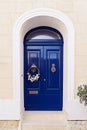 Blue entrance door decorated by Christmas wreath. Outdoor Christmas decoration Royalty Free Stock Photo