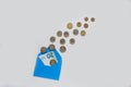 Blue envelope on a light background. A lot of coins, different denominations. Inside the envelope is a banknote of 20 euros. Royalty Free Stock Photo