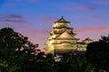 Blue evening sky mixes with sunset color as moon sets over Himeji Castle Royalty Free Stock Photo